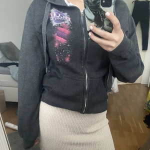 Zip up tröja med tryck - En zip up hoddie med tryck på fram och baksida. Tröjan är i storlek XS-M. Jag har använt tröjan knappt något så den är i bra skick.