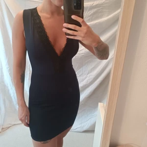 Klänning - Använd fåtal gånger. Kort med djup urringning 