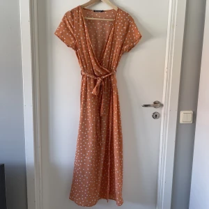 Rut & circle orange omlottklänning midi S - Omlottklänning från Rut & Circle. Orange med vita prickar i storlek S, midilängd. Använd en gång så i nyskick ☺️resår i midjan med knytband. Urringad. Faller fint på kroppen 🥰