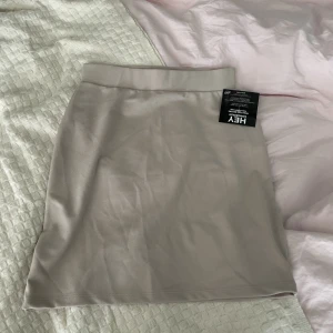 Mini skirt - Helt ny kjol med prislappar kvar från Nelly i beige färg. Nypris: 249kr.  Kan mötas upp i Stockholm annars står köpare för frakten.