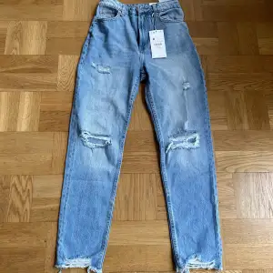 Säljer dessa blåa mom jeans från Bershka. ST 34. Byxorna är aldrig använd endast testade. Dom säljs pga att dom inte kommer till användning. Frakt tillkommer för köparen! Ingen ångerrätt! 