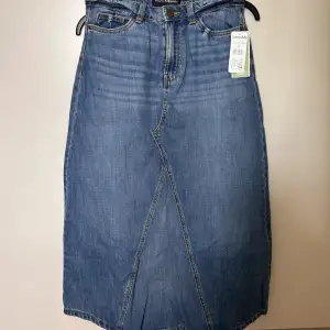 Oanvänd långkjol i jeans! Strl 34. Liten spricka under gylf som fanns vid köp men inget som syns när kjolen är på. 