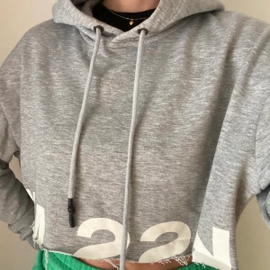 Croppad hoddie strl M - En croppad grå hoddie från NA-KD, i storlek M 