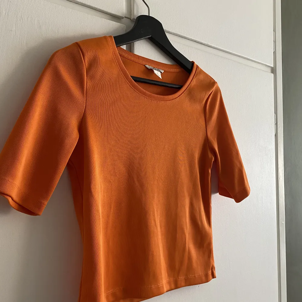 Orange croppad t-shirt i storlek S.  Lätt glansig finish!  Smalribbat tyg Knappt använd, nyskick! . T-shirts.