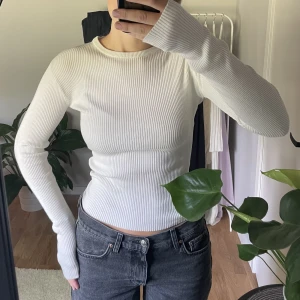 Vit ribbad långärmad  - En vit långärmad ribbad tröja ifrån Nakd. Jätteskönt material och har långa armar, rund halsringarna. Enkel och snygg.