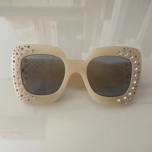 Solglasögon  - Krämvita oversizade solglasögon med med färgglada diamante stenar