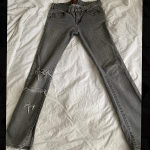 gråa lågmidjade jeans med slits nertill, innerbenslängden 79cm midjemått 40x2 cm. bra skick, köpta secondhand 🤍