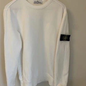 Stone Island Sweatshirt Vit - Otroligt fin Stone island sweatshirt i färgen vit, som har ett jätte fint skick (9,5/10) använd ett fåtal gånger, inte en ända skråma på tröjan helt stilren och fin, betalning sker via Swish, Priset kan diskuteras, hör av dig vid frågor!
