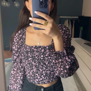 Blommog topp från H&M - Jättesöt svart topp med ljusrosa blommor på från H&M! Säljes då den sitter för tajt över bysten för mig. Den har stretch på baksidan och väldigt tunt fint material till sommaren! Hör gärna av er vid vidare intresse eller frågor ❤️‍🔥