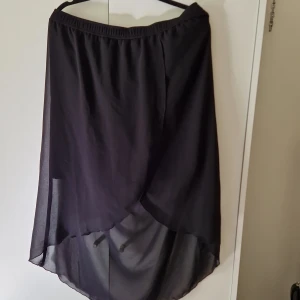 Kjol - (Obs, kjolen är mkt bredare vid midjan än vad som syns på bild). Stretchig midja, polyester.