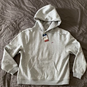 Ny Tommy Hilfiger hoodie  - Säljer en ny grå Tommy Hilfiger hoodie med lappen kvar.  Äkta såklart! Storlek L