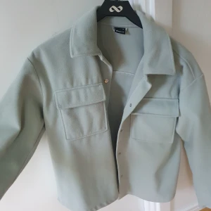 Vår/höst jacka - Säljer denna jättefina jacka från Gina Tricot. Sorlek XS men passar perfekt till mig som brukar ha S/M. Jättefin grön färg, jackan är som ny. Säljs för 80kr+frakt.