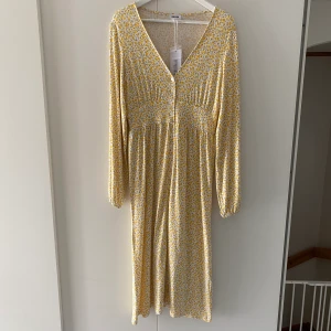 Luella button dress - Långklänning från Bubbelroom i modellen Luella i strl S. Vit med gula blommor. Ny med lappar kvar, köpte två färger och glömde returnera ena 😅 Från djur- och rökfritt hem 🌱