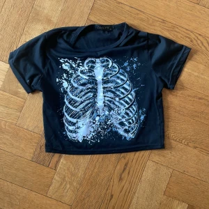 Svart skelett babytee  - Svart babytee med ett skelett i mitten. Använder inte den längre