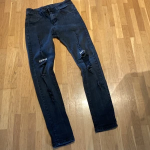 Grå stretch jeans herr - Hål på knän och revor  Står limited edition över knäna Hål i en ficka 