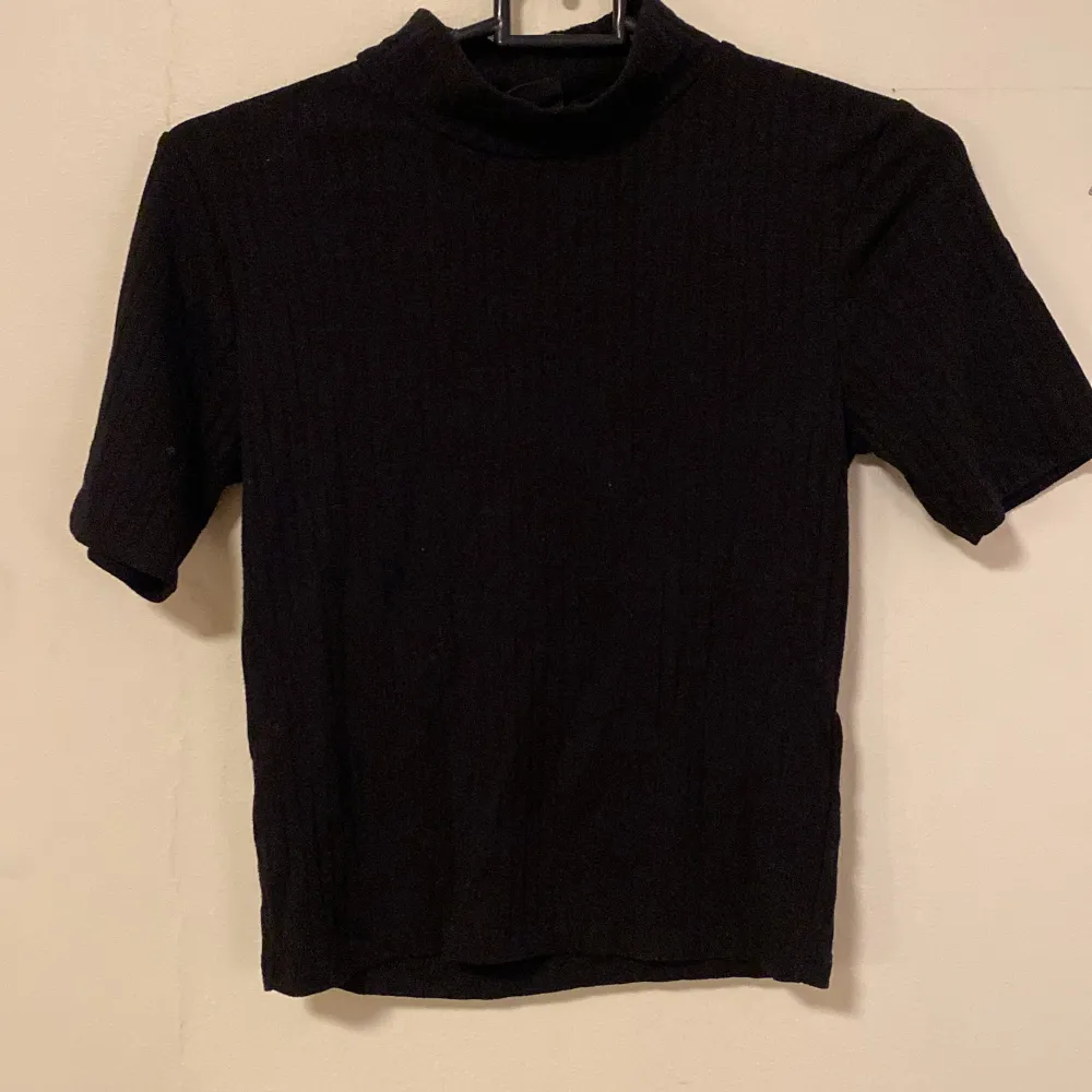 Stretchig, svart, ribbad T-shirt från ginatricot. T-shirts.