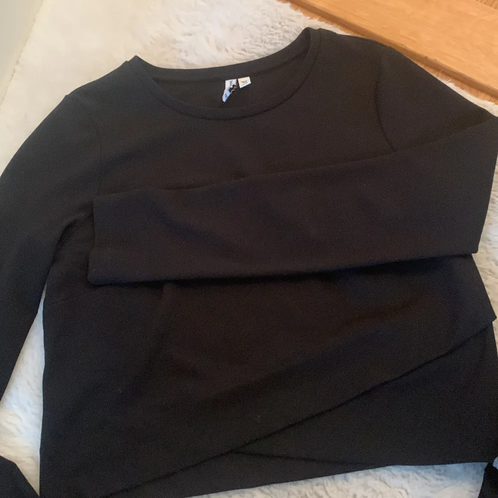En svart långärmad tröja med mönster längst ner. Aldrig använt . Toppar.