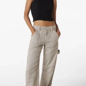 Bershka bukser str 32 - Flotte stribede carpenter bukser. Str 32 i god stand, grunden til der står brugt er fordi der er en plet på bagdelen af bukserne.  Byd gerne <3