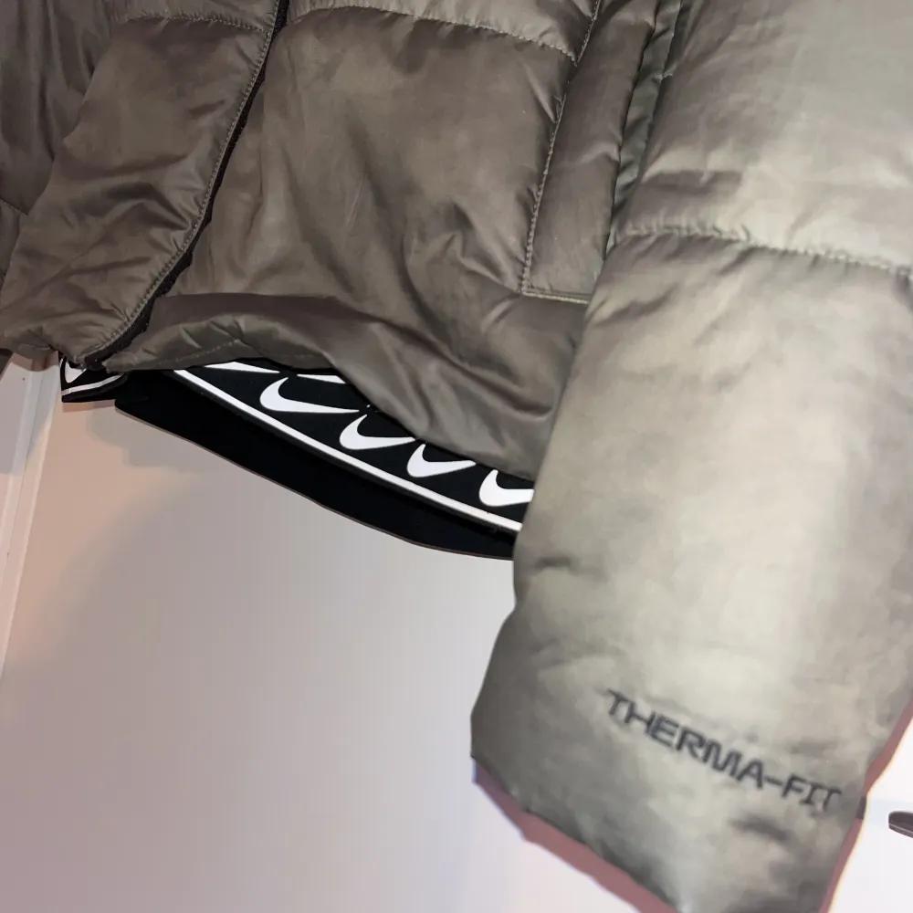 Nike Sportswear Therma Fit Repel  Puffer Jacket i fortfarande bra skick som är köpt från Junkyard. Längden är medel och har detaljer nedtill och i luvan. Nypriset är 1500 kr.. Jackor.