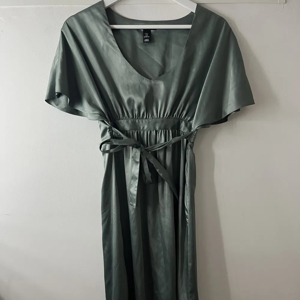 En grön lite metallic klänning som är använd få gånger. Går att knyta i midjan efter eget önskemål! Kör för 100kr + spårbar frakt. Klänningar.