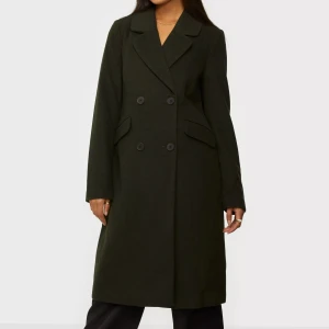 Höstkappa - Kappa från Only,  Rak modell,  Mjuk kvalitet,  Försluts med dubbelknäppning fram,  Två fickor framtill,  Fodrad.  Kappan är mörkgrön.  Material: 57% Polyester, 35% Ull, 3% Polyamid, 3% Akryl, 2% Viskos