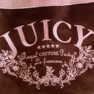 JUICY COUTURE VÄSKA - Ikonisk 2000 tals juicy couture väska! Som man ser på bilderna är den lite sliten