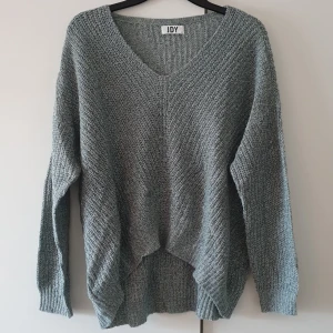 Stickad tröja  - V-ringad tunnstickad långärmad tröja från jdy. Storlek Medium  Oanvänd/nyskick Färgen är grå/grön  Pris 200kr kan diskuteras vid snabb affär.  Så fin längre bak och lite kortare framtill.