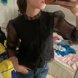 Svart blus med mesh - Snygg blus med mesh och volanger både vid hals och ärmar✨ passar till allt