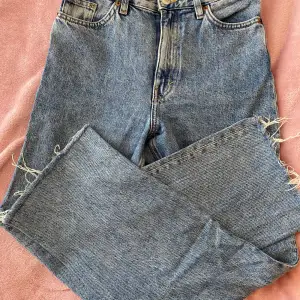 Fina jeans från monki, högmidjade, snygg tvätt. Avklippta nertill. Innerbenslängd 73 cm, midjan rakt över 34 cm.  