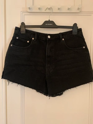 Svarta highwaist jeansshorts, Weekday - Svarta jeansshorts från Weekday, inköpta nu i sommar och använda en gång. Highwaist. Inget att anmärka på. Strl 33, passar M-L. 