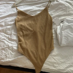 Stringbody GULD - Supersnygg guld body från hm, den är aldrig använd då storleken inte passar. 