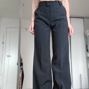 Svartrandiga kostymbyxor - Vintage kostymbyxor med vida ben. Insydda i midjan för att passa strl 36 (original 38). Fler bilder finns. Pris kan diskuteras