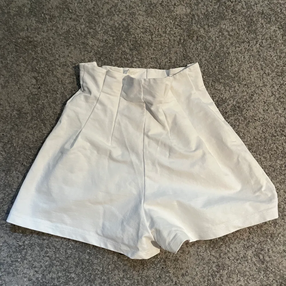 Verkligen så fina vita shorts som är lite vidare med en högmidja och volang längs Landgren upptill. Dessa shorts är verkligen ett måste och går att ha till både vardags, men även finare tillfällen!. Shorts.
