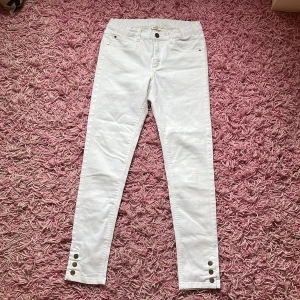 Jeans - Det är stretchiga anklelånga skinnyjeans med knappar längst ner på byxbenet 