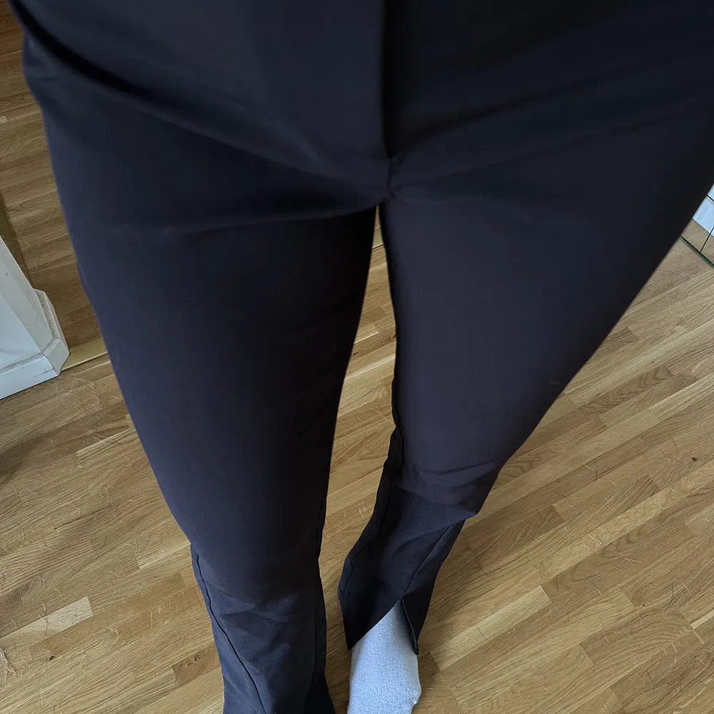 Svarta kostymbyxor med slits från NA-KD i storlek 34. Jeans & Byxor.