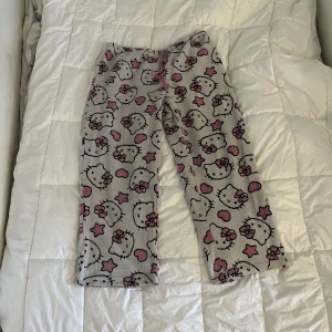 HelloKitty byxor - Skitcoola byxor köpta second hand. Väl använda men är bra kvalitet så alla sömmar och tyg är ändå toppskick. Står storlek 11-13år men skulle ändå säga att de passar upp till L, längd på byxan är 97cm. Katt finns i hemmet <3 