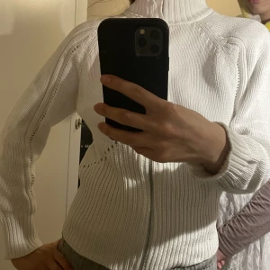 Stickad - Vit stickad turtelneck. Med dragkedja i mitten. Lite kortare i ärmarna. 