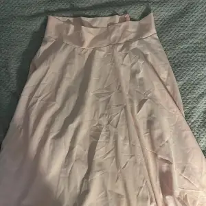 En halvlång rosa kjol i sidenmaterial