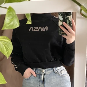 NASA cropped tröja - Cropped tröja med reflektiv text samt streck på sidorna. Sprickor i reflexen på loggan. 🐜