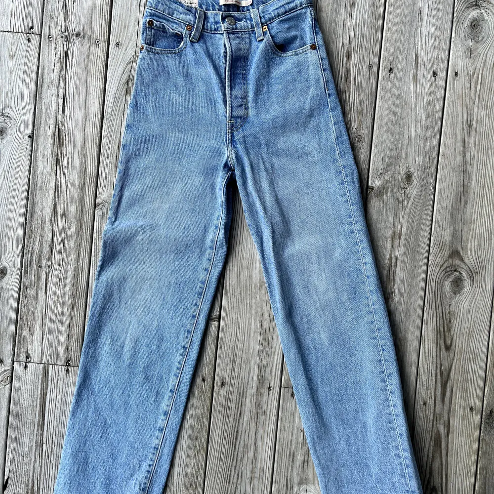 Ett par ljusblåa levi’s jeans i modellen ribcage straight som blivit för små för mig. Har använts sparsamt och är därför i bra skick. Storlek 23/minsta storleken. Mildjemåttet är 63 cm. Nypris är 1200 men säljer för 400 kr + frakt. Skriv vid intresse. . Jeans & Byxor.