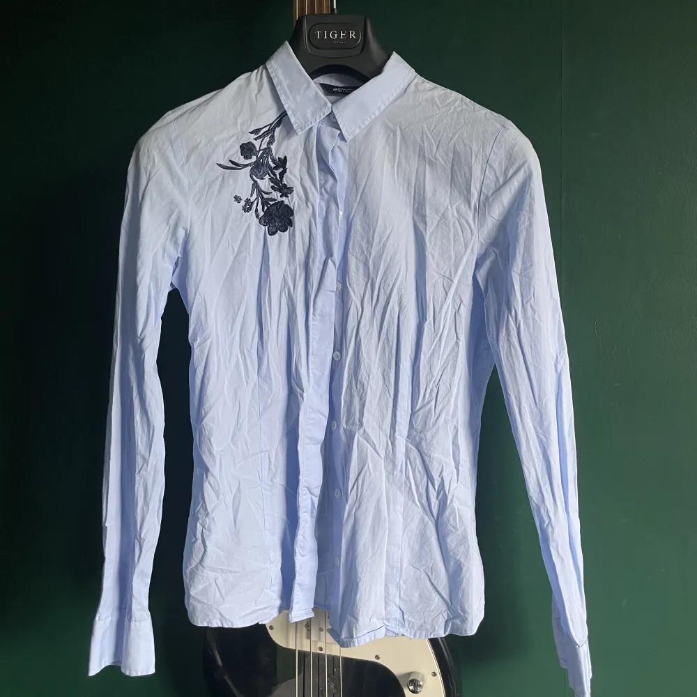 croppad blå skjorta med broderade blommor på bröstet 😇sorry att den är så skrynklig orkade verkl inte stryka den lol. Skjortor.