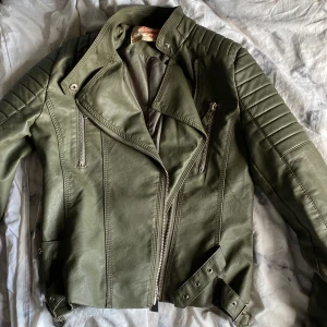 Skinnjacka  - Hej, säljer min olivgröna skinnjacka som jag växt ut och därmed inte använder längre. Super fin och passar till mycket. Skriv om fler bilder eller frågor.🫶🏻