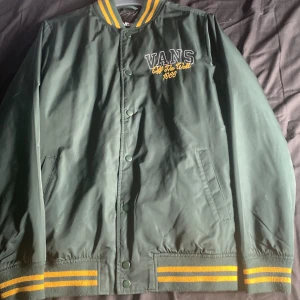 Vans jacka - Jag säljer denna vans jacka för det inte är min stil längre. Perfekt skick och använd ca 2ggr. Mörkgrön med en ros ibak. Vår/ höst jacka. Sorlek Xs men passar även S