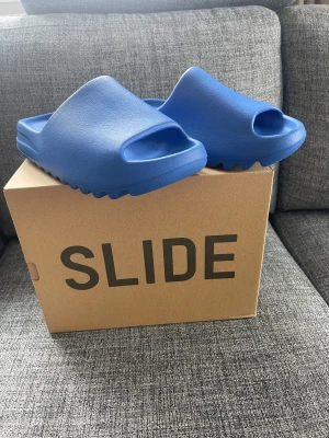 Yeezy Slide Azure - Säljer mina Yeezy Slide Azure i storlek 43 (sitter bra på 40-42) som är köpte på CONFIRMED appen. Endast testade. Som nya. Digitalt kvitto finns.