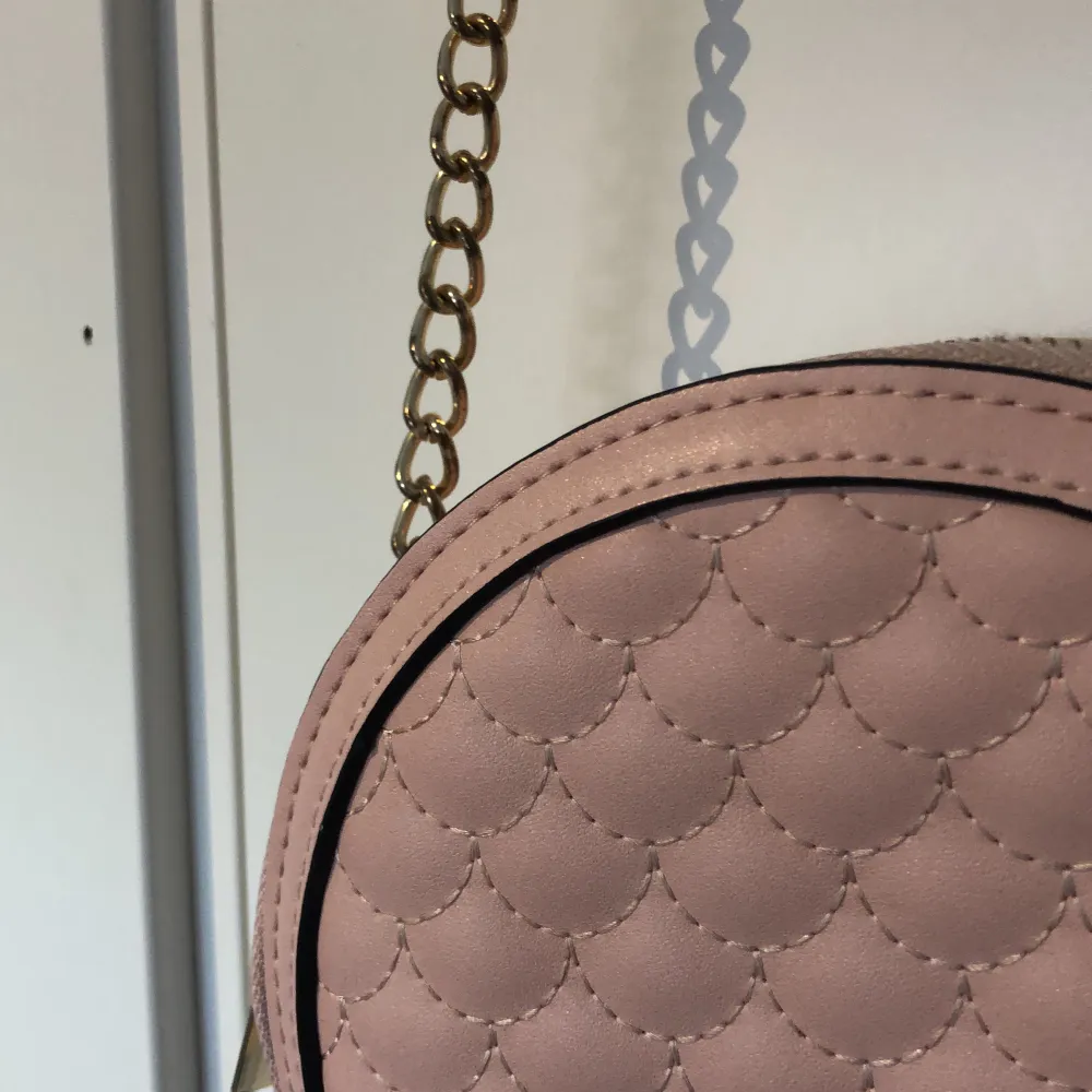 En liten rosa handväska från Holly & White i bra skick som inte har kommit till användning . Väskor.