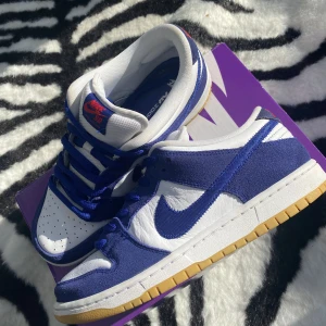 Nike SB dunk low ” La dodgers ”  - - Skick 7 , 8 /10  - flaw finns på de blåa snören.  - Storlek 42,5 ( US 9 )  - låda, extra snören finns.  - pappret till lådan är borta.   Mvh PlugYstad 
