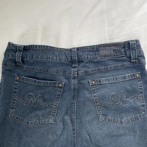 raka jeans  - Skitcoola raka jeans med detaljer på fickorna ⚡️ Knappen har tyvärr lossnat, så antingen kan man sy på en ny eller ha dem nedvikta som jag har! Vet inte storleken men skulle uppskatta S/M, sitter bra på mig som är 173. Priset är diskuterbart!!