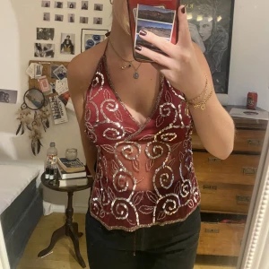 Fest top - Lila/röd/rosa festtopp med öppen rygg. Använd en gång på halloween fest för ett par år sedan! Står storlek M i den men skulle säga att den även passar S och Xs då man själv knyter den hur tajt man vill!