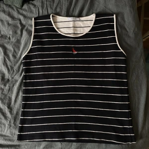 Randigt linne - Randigt linne med liten båt på, står storlek XL men passar från M