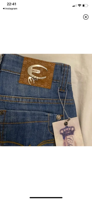 Chicago jeans - Helt nya Chicago jeans, aldrig använda. Lågmidjade+bootcut. Storlek 28. Specifika mått: midja: 34cm x2. Innerbenslängd: 78cm.  Benöppning: 22cm. Lår: 23.5cm. Från skrev till midja: 19cm. 